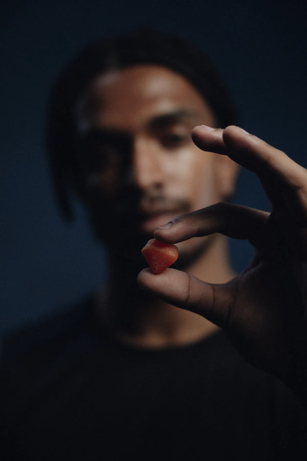A CoreIQ creatine gummy held between two fingers