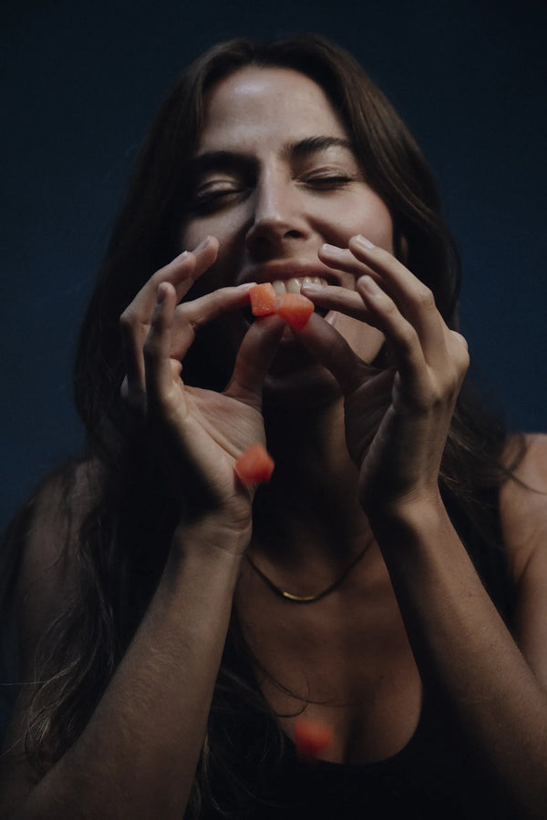 Woman eating CoreIQ creatine gummies