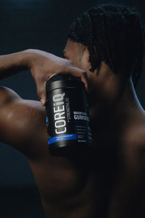 CoreIQ Magnesium Gummies jar held on the shoulder