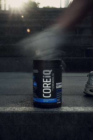 CoreIQ Magnesium Gummies jar on a step, runner passing
